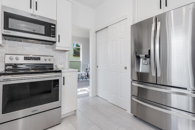 kitchen with light countertops, white cabinetry, decorative backsplash, and appliances with stainless steel finishes