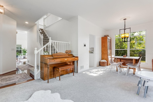 interior space featuring ornamental molding, carpet flooring, a chandelier, and stairs