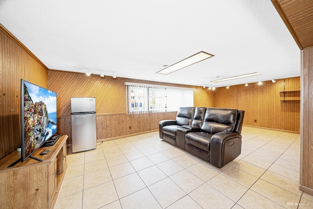 living room with wood walls, light tile patterned floors, and track lighting