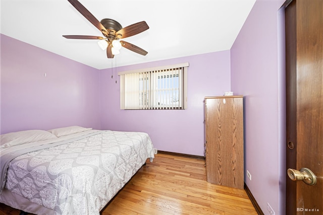 bedroom featuring ceiling fan, baseboards, and wood finished floors