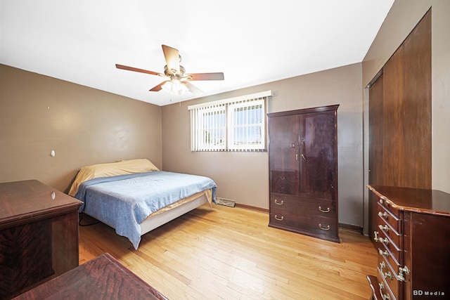 bedroom featuring baseboards, light wood-type flooring, a ceiling fan, and a closet
