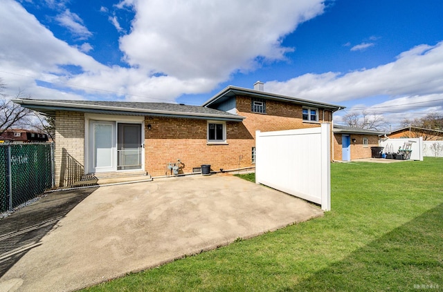 back of house with a patio area, brick siding, and a lawn