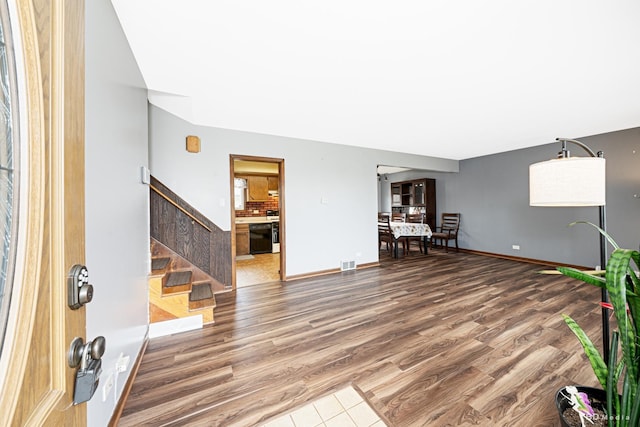 foyer with visible vents, baseboards, wood finished floors, and stairs