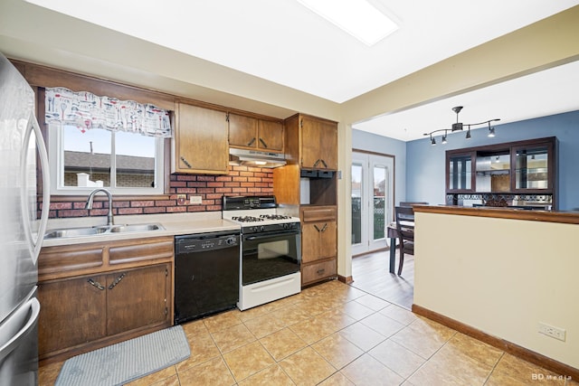 kitchen featuring white range with gas cooktop, freestanding refrigerator, under cabinet range hood, dishwasher, and a sink