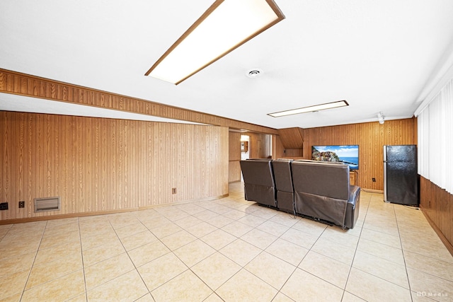 unfurnished living room featuring light tile patterned floors, visible vents, and wooden walls