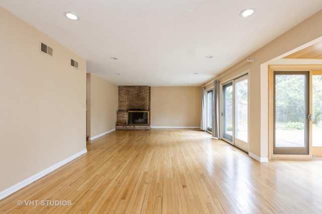 349 Ridge Rd, Kenilworth, IL 60043 - unfurnished living room featuring light wood-style flooring, a brick fireplace, baseboards, and visible vents