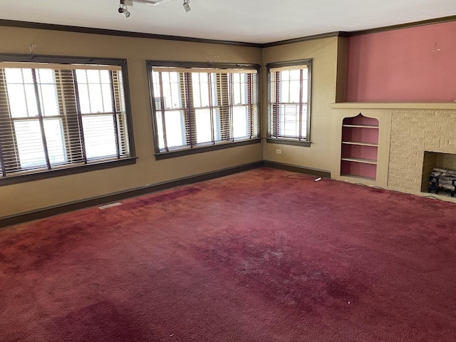 unfurnished living room featuring carpet, built in features, visible vents, and crown molding