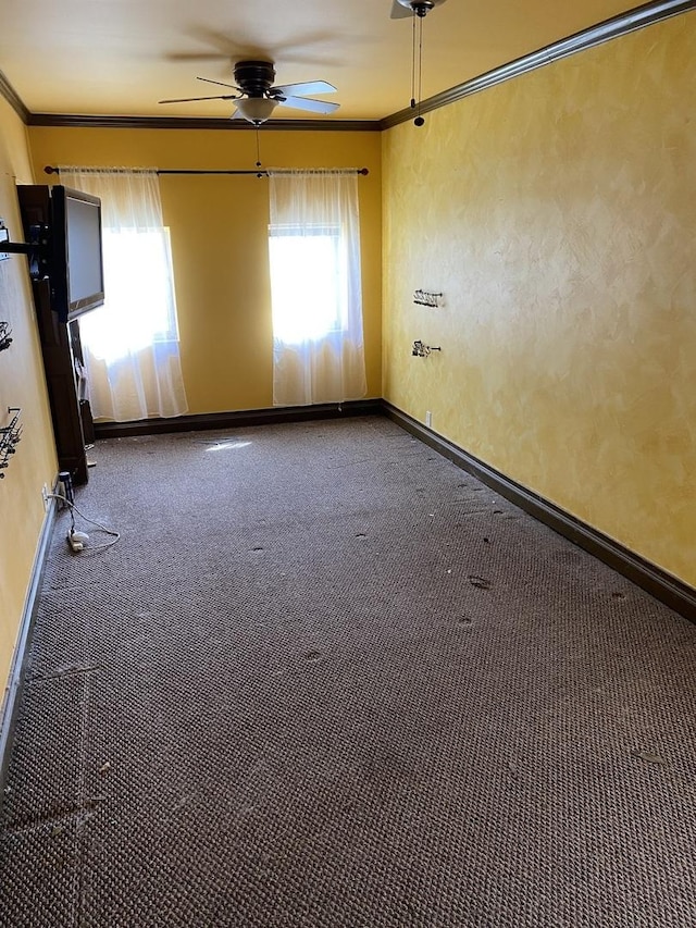 carpeted spare room with crown molding, baseboards, and plenty of natural light