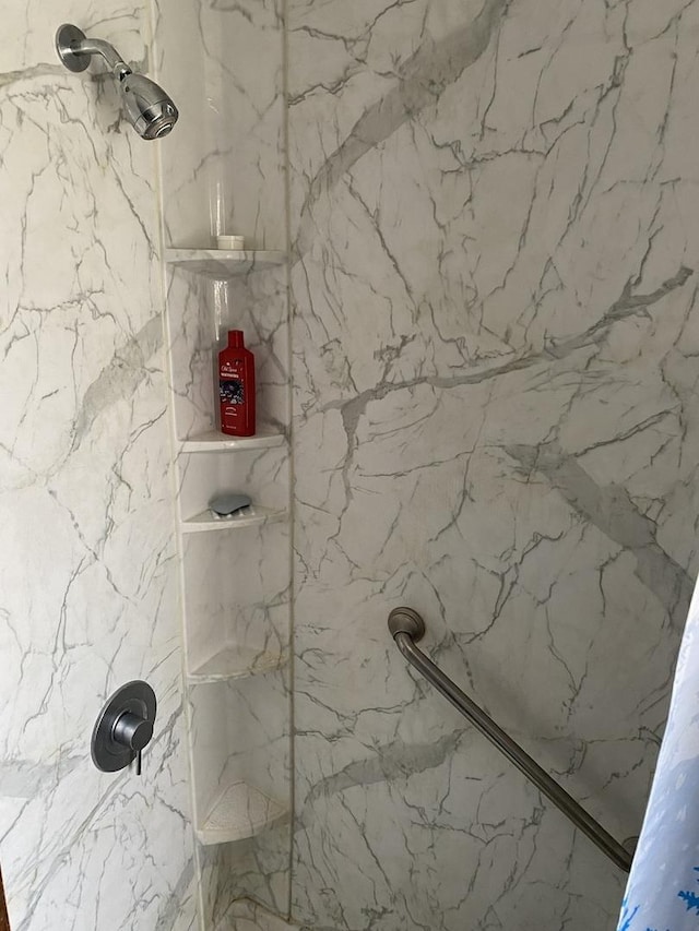 bathroom with a marble finish shower