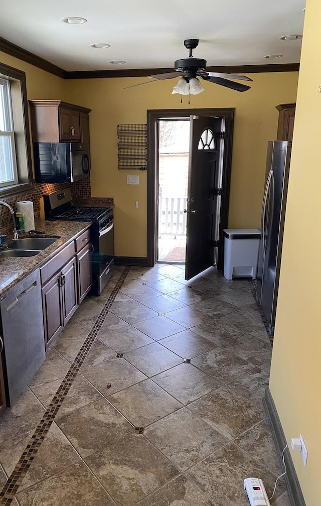 kitchen featuring a sink, ornamental molding, stainless steel appliances, and plenty of natural light