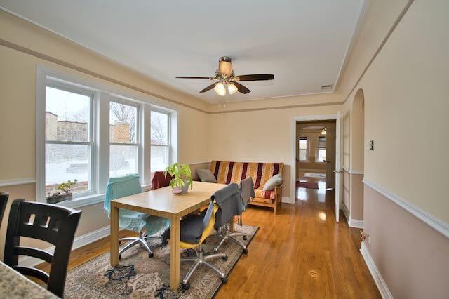 6237 N Mozart St, Chicago, IL 60659 - dining room with light wood finished floors, arched walkways, ceiling fan, and baseboards