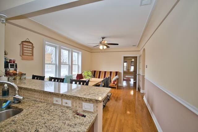 6237 N Mozart St, Chicago, IL 60659 - kitchen with a sink, a wealth of natural light, ceiling fan, and light stone counters