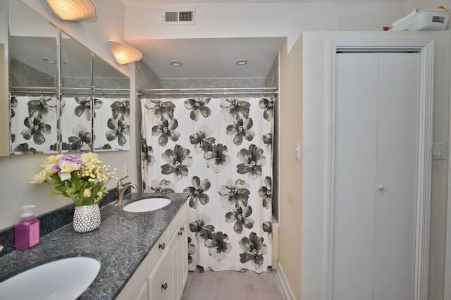 6237 N Mozart St, Chicago, IL 60659 - full bathroom featuring a shower with shower curtain, double vanity, visible vents, and a sink