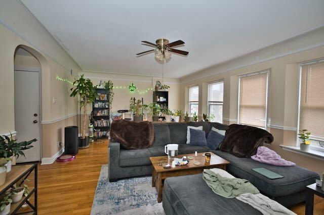 6237 N Mozart St, Chicago, IL 60659 - living area with light wood-style floors, baseboards, a ceiling fan, and arched walkways