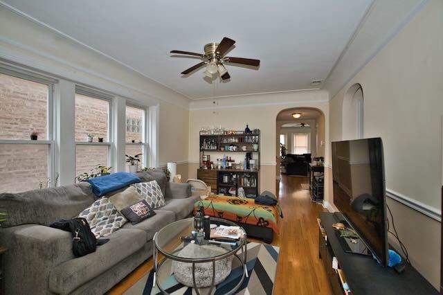 6237 N Mozart St, Chicago, IL 60659 - living area featuring arched walkways, plenty of natural light, wood finished floors, and ceiling fan