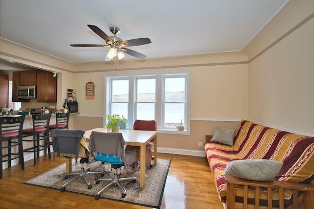 6237 N Mozart St, Chicago, IL 60659 - dining space with light wood-style floors, baseboards, and ceiling fan