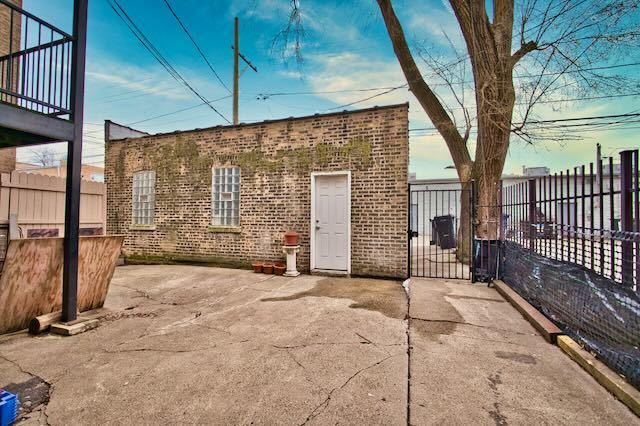 6237 N Mozart St, Chicago, IL 60659 - rear view of property with a patio area, fence, and brick siding