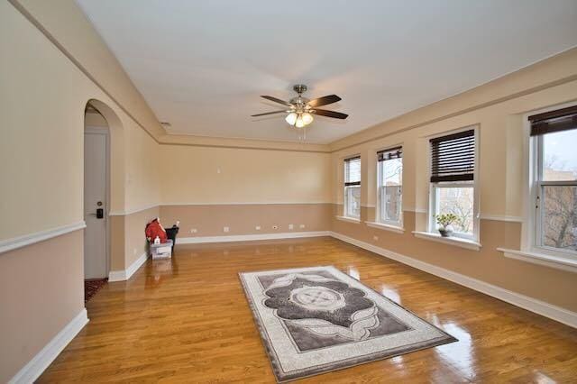 6237 N Mozart St, Chicago, IL 60659 - spare room with light wood-type flooring, ceiling fan, plenty of natural light, and arched walkways