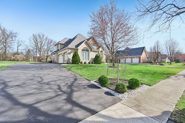 view of front of house featuring a front lawn, a garage, and aphalt driveway