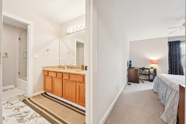 interior space featuring a sink, connected bathroom, and baseboards