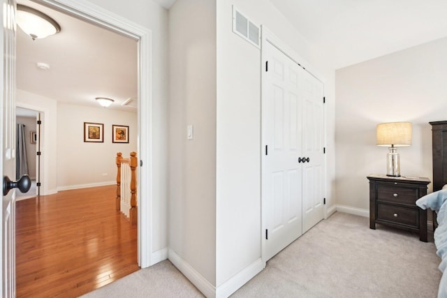 interior space with light carpet, baseboards, a closet, and visible vents