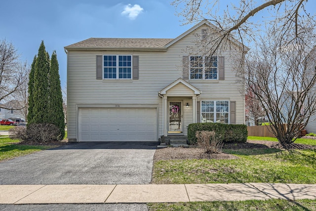 traditional home with a garage, roof with shingles, driveway, and fence