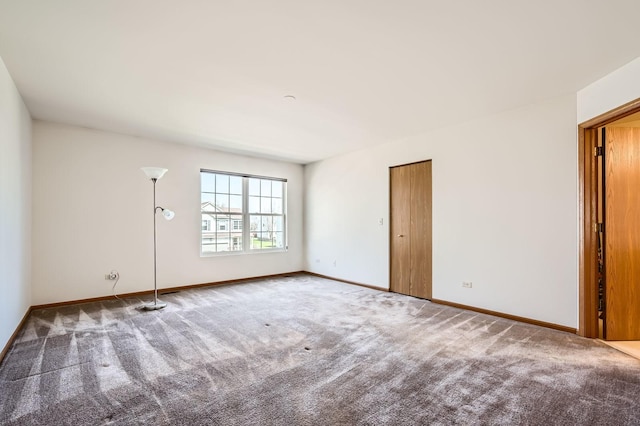 carpeted empty room with baseboards