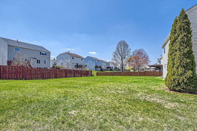 view of yard featuring fence and a residential view