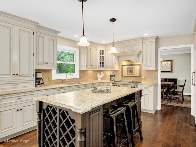 2 Stirrup Cup Ct, Saint Charles, IL 60174 - kitchen with a center island, a sink, decorative backsplash, pendant lighting, and light stone counters