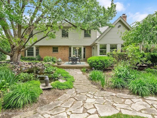 2 Stirrup Cup Ct, Saint Charles, IL 60174 - back of property featuring brick siding, a chimney, outdoor dining area, and a patio area