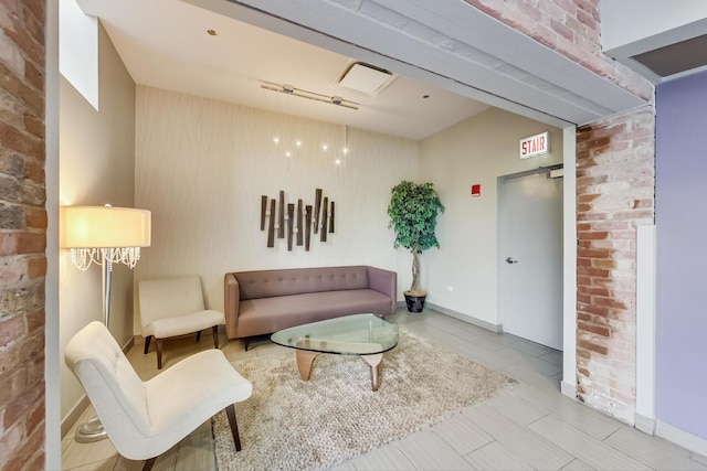 living room with brick wall, baseboards, and rail lighting