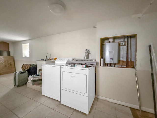 clothes washing area featuring light tile patterned flooring, a sink, water heater, and washer and dryer