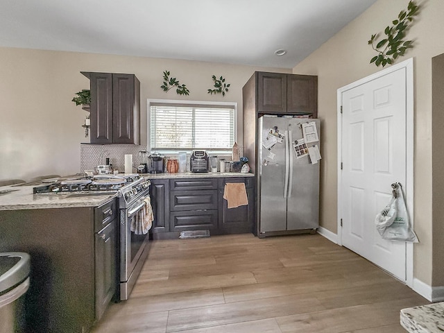 kitchen with stainless steel appliances, baseboards, dark brown cabinetry, and light wood-type flooring