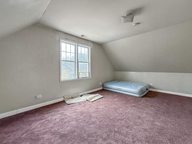 unfurnished bedroom featuring carpet, baseboards, vaulted ceiling, and visible vents