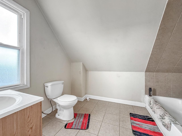 full bathroom featuring a washtub, baseboards, toilet, vanity, and tile patterned flooring