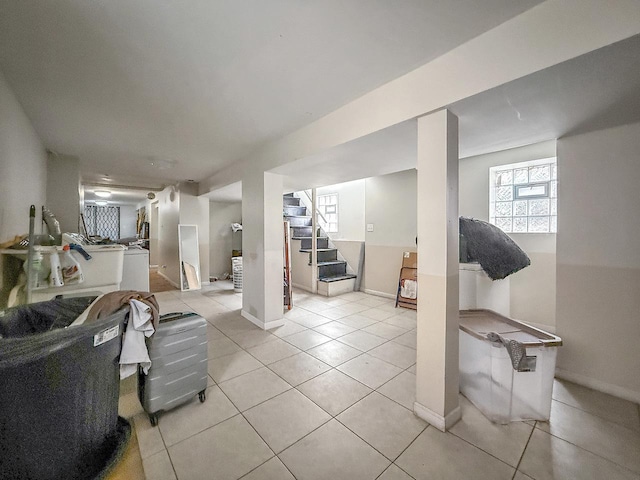 below grade area featuring stairs, baseboards, and light tile patterned floors