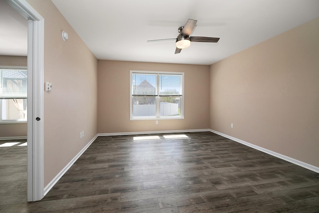 unfurnished room featuring dark wood-style floors, baseboards, and a ceiling fan