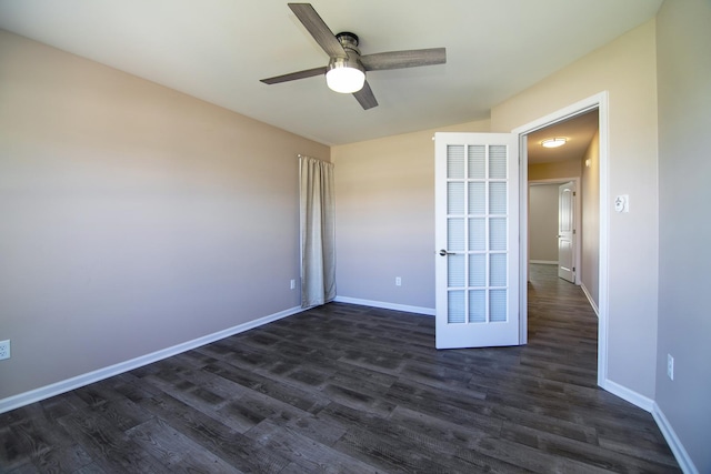 spare room with dark wood-type flooring, baseboards, and a ceiling fan