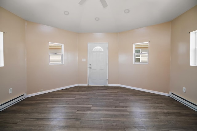 entrance foyer featuring a wealth of natural light, a baseboard heating unit, and wood finished floors