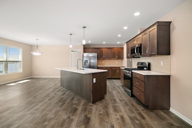 kitchen with stainless steel appliances, baseboards, backsplash, and dark wood finished floors