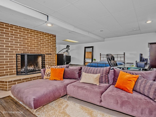 living room featuring a paneled ceiling and a fireplace