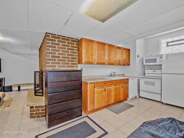 kitchen featuring a sink, light tile patterned floors, a drop ceiling, and white appliances
