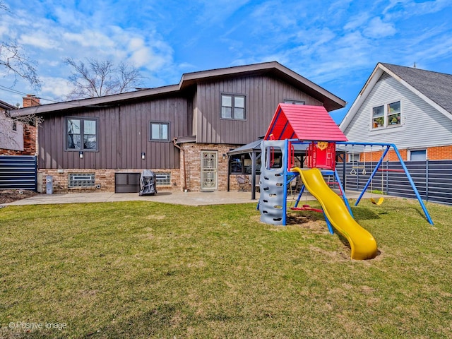 back of house with a patio, a playground, a lawn, and brick siding