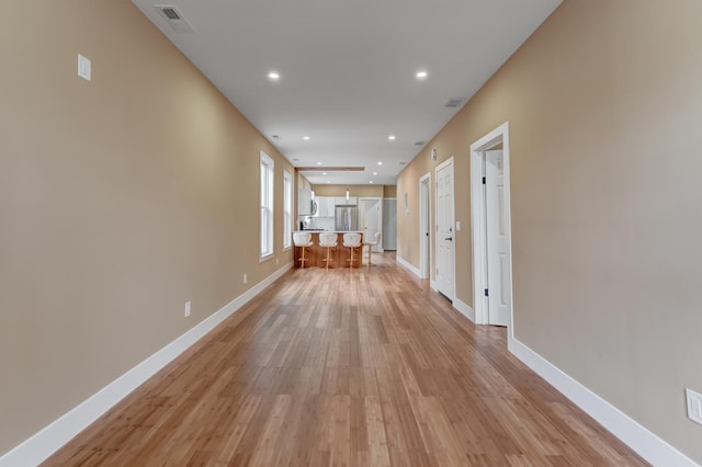 corridor featuring baseboards, visible vents, recessed lighting, and light wood-type flooring