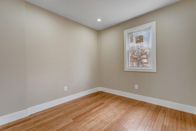empty room featuring baseboards, light wood-style floors, and recessed lighting