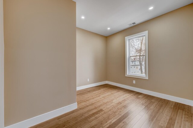 empty room with baseboards, light wood-style floors, and recessed lighting