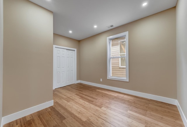 empty room with baseboards, visible vents, recessed lighting, and light wood-type flooring