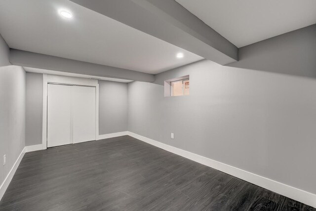 below grade area with dark wood-style flooring, baseboards, and recessed lighting