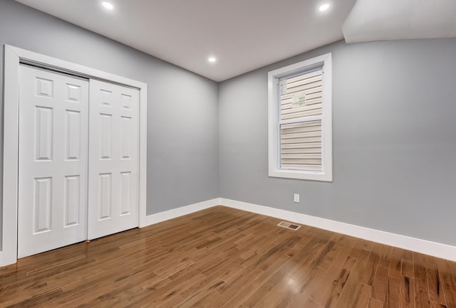 unfurnished bedroom featuring baseboards, visible vents, wood finished floors, and recessed lighting