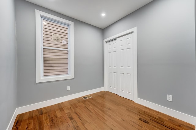 spare room with wood finished floors, recessed lighting, baseboards, and visible vents